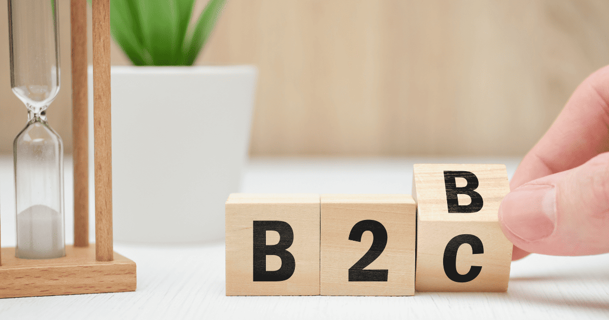 B2B spelled out on wooden blocks on desk with hourglass and plant