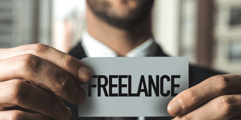 man holding a page that says freelance