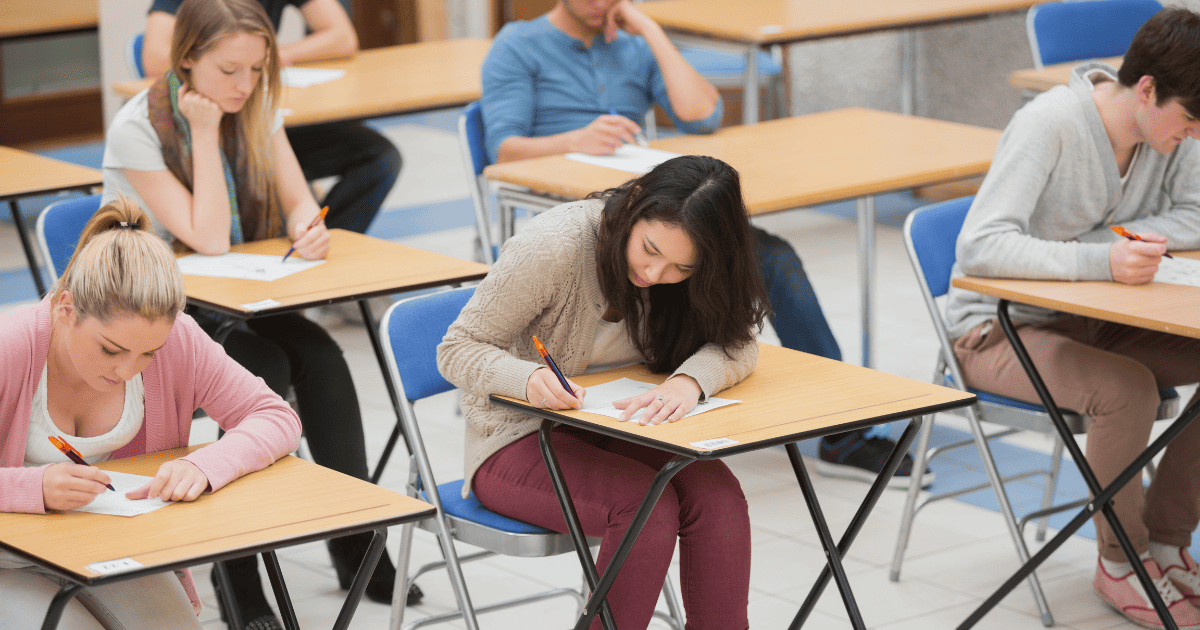 students writing at desks in classroom