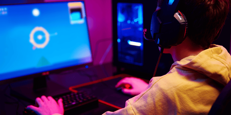 student playing a video game wearing headphones