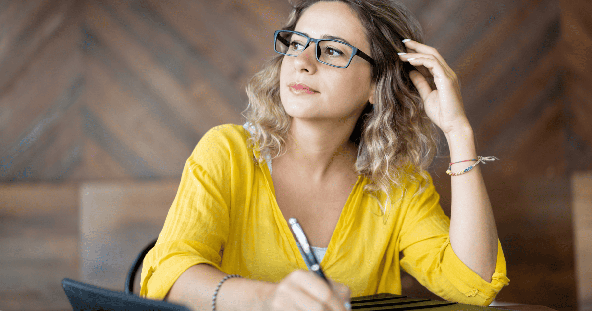 woman at desk thinking about writing